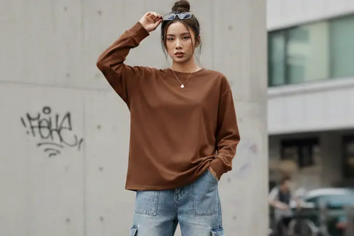 Model wearing the brown oversized long-sleeve T-shirt paired with stylish, light-wash cargo pants to emphasize the Y2K aesthetic and versatile streetwear look.