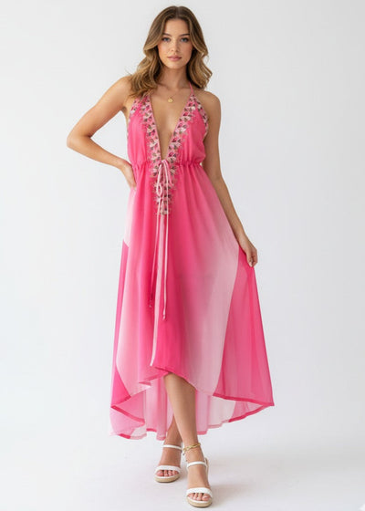 Woman wearing a pink dress with floral details on a white background